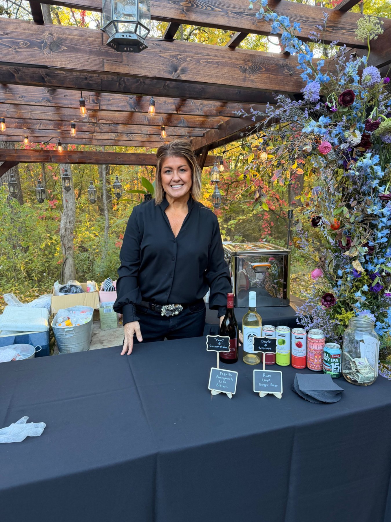 Nikki behind a decorated outdoor bar at an event