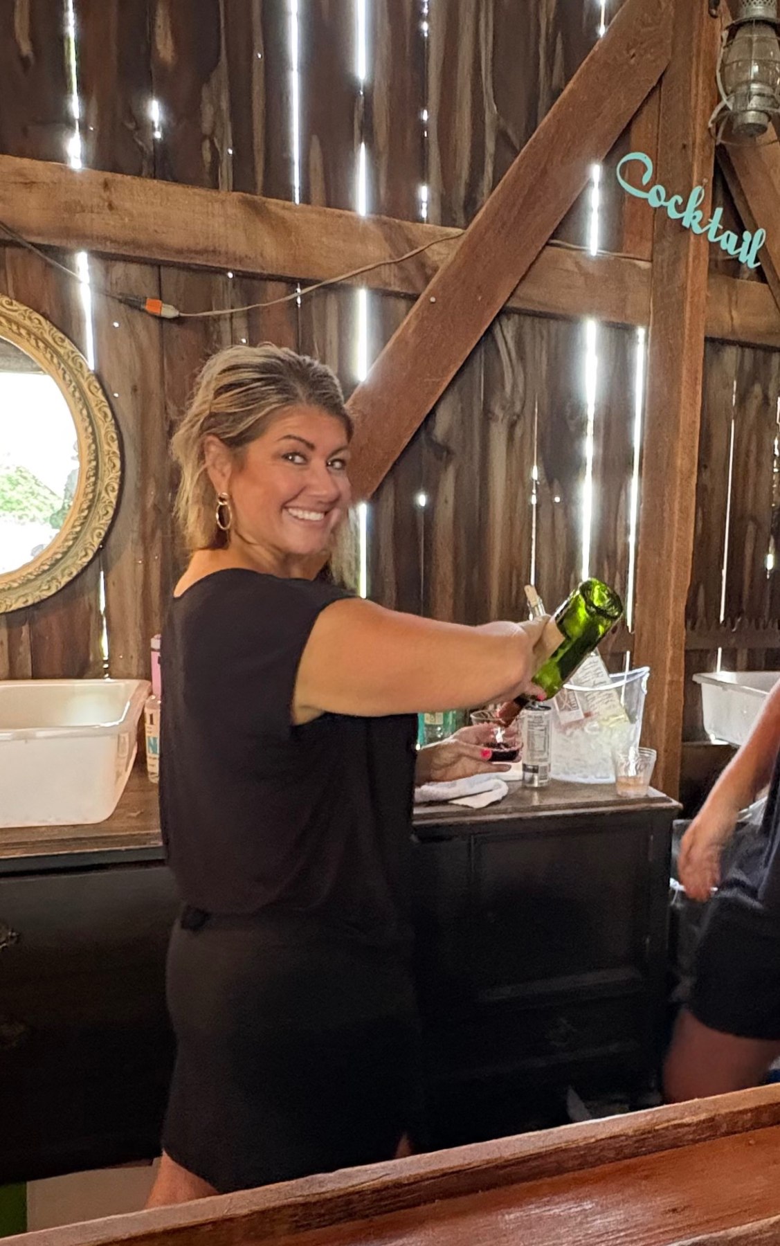 Nikki pouring a drink behind the bar